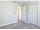 Bedroom showcasing neutral walls, wood-look floors, closet, and a hallway entrance at 1203 W 20Th St, Sanford, FL 32771