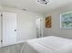 Neutral bedroom featuring light gray floors, white trim, closet, window, and modern lighting at 1203 W 20Th St, Sanford, FL 32771