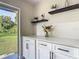 Bright kitchen featuring white cabinets, modern hardware, and floating shelves for decor at 1203 W 20Th St, Sanford, FL 32771