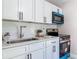 Modern kitchen featuring white cabinets, quartz countertop, subway tile backsplash, and stainless steel appliances at 1203 W 20Th St, Sanford, FL 32771