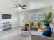 Bright living room with a grey sofa, accent chairs, ceiling fan, and modern decor at 1203 W 20Th St, Sanford, FL 32771