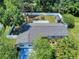 Aerial view of a well maintained backyard, shed, and home with mature trees and landscaping at 1229 Jeffery Dr, Port Orange, FL 32129