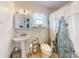A bright bathroom featuring a pedestal sink and a seashell-themed shower curtain at 1229 Jeffery Dr, Port Orange, FL 32129