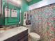 A bathroom with a wood vanity, large mirror, and floral print shower curtain at 1229 Jeffery Dr, Port Orange, FL 32129