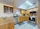 Bright kitchen featuring stainless steel appliances, tile flooring, skylight, and light wood cabinets at 1229 Jeffery Dr, Port Orange, FL 32129