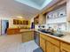 Spacious eat-in kitchen with wood cabinets, tile floor, island and access to laundry at 1229 Jeffery Dr, Port Orange, FL 32129