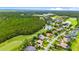 Wide aerial shot displaying homes nestled within a lush, wooded landscape featuring a golf course and pond at 1324 Dovercourt Ln, Ormond Beach, FL 32174