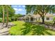Backyard featuring large lawn, mature trees, and enclosed pool area at 1324 Dovercourt Ln, Ormond Beach, FL 32174