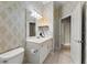 Bathroom features a white vanity, patterned wallpaper, and tiled floors at 1324 Dovercourt Ln, Ormond Beach, FL 32174