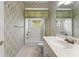 Clean bathroom with patterned wallpaper, white fixtures, and a bathtub with a shower at 1324 Dovercourt Ln, Ormond Beach, FL 32174
