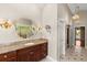 Bathroom vanity with a decorative mirror, marble countertop, and decorative sconce lighting at 1324 Dovercourt Ln, Ormond Beach, FL 32174