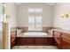 Elegant bathroom featuring a soaking tub with marble accents, and cabinets, and natural light at 1324 Dovercourt Ln, Ormond Beach, FL 32174