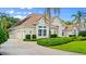 Well-maintained house with a side-entry garage, tile roof, lush landscaping, and a paved driveway with ample parking at 1324 Dovercourt Ln, Ormond Beach, FL 32174