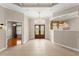 Welcoming foyer with double doors, tile flooring, transom windows, tray ceiling, and a decorative chandelier at 1324 Dovercourt Ln, Ormond Beach, FL 32174