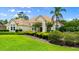 Elegant home featuring a tile roof, columned entryway, and well-maintained landscaping with flowering trees at 1324 Dovercourt Ln, Ormond Beach, FL 32174