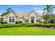 Attractive home with a tile roof, prominent entryway, and lush green lawn with manicured shrubbery at 1324 Dovercourt Ln, Ormond Beach, FL 32174