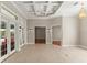 Open-concept living area featuring tiled floors, coffered ceilings, and double doors leading to an outdoor space at 1324 Dovercourt Ln, Ormond Beach, FL 32174