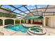 Enclosed pool area with spa, ample seating, and covered patio at 1324 Dovercourt Ln, Ormond Beach, FL 32174