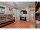 Cozy living room with wood floors, neutral walls, and brown leather furniture at 137 Fort Smith Blvd, Deltona, FL 32738