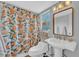 Charming bathroom with a colorful fruit-themed shower curtain and pedestal sink at 1398 5Th Ave, Deland, FL 32724