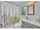 Cozy bathroom showcasing a vanity sink, updated lighting, and a vibrant cactus shower curtain at 1398 5Th Ave, Deland, FL 32724