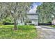 View of the charming two story home surrounded by lush landscaping and an open front lawn at 1398 5Th Ave, Deland, FL 32724