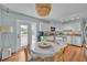 Bright kitchen with white cabinets, hardwood floors, a dining table, and backyard access at 1398 5Th Ave, Deland, FL 32724