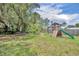 Backyard with a playground, picnic table, and mature trees at 1398 5Th Ave, Deland, FL 32724