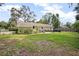 Green backyard with a patio, grill, outdoor seating, and well-maintained lawn, ideal for outdoor activities at 1402 E Voorhis Ave, Deland, FL 32724