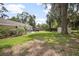 Spacious backyard with green grass, mature trees, and a cozy patio area for outdoor entertaining at 1402 E Voorhis Ave, Deland, FL 32724