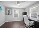 Bright room featuring hardwood floors, a ceiling fan, and natural lighting from two large windows at 1402 E Voorhis Ave, Deland, FL 32724