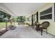 Inviting covered front porch with seating and a view of the front yard at 1402 E Voorhis Ave, Deland, FL 32724