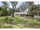 Charming single-story home featuring a well-maintained lawn and mature trees at 1402 E Voorhis Ave, Deland, FL 32724