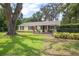 Beautiful home with lush green lawn and a charming front porch area at 1402 E Voorhis Ave, Deland, FL 32724