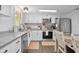 Well-lit kitchen with white cabinets, stainless steel appliances, and granite countertops at 1402 E Voorhis Ave, Deland, FL 32724
