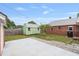 Fenced backyard with brick house, shed, patio and small trees at 1411 Cliff Ave, Eustis, FL 32726