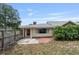 Fenced backyard with patio, small tree, red door, and yellow siding at 1411 Cliff Ave, Eustis, FL 32726