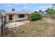 Fenced backyard with patio, small tree, red door, and yellow siding at 1411 Cliff Ave, Eustis, FL 32726