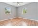 Bright bedroom with wood flooring, two windows, ceiling fan and neutral paint at 1411 Cliff Ave, Eustis, FL 32726