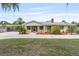 Charming single-story home featuring a quaint yellow facade, red-brick chimney, and a covered parking area at 1411 Cliff Ave, Eustis, FL 32726