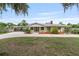 Quaint yellow single-story home with covered parking, lush landscaping, and a charming front entrance at 1411 Cliff Ave, Eustis, FL 32726