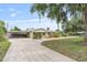 Street view of a single-story home with mature trees, covered parking, and a well-maintained front yard at 1411 Cliff Ave, Eustis, FL 32726