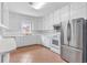 Well-lit kitchen features stainless steel refrigerator, range, tiled backsplash, and ample cabinet space at 1411 Cliff Ave, Eustis, FL 32726