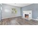 Cozy living room featuring hardwood floors, fireplace, and natural light at 1411 Cliff Ave, Eustis, FL 32726