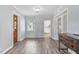 Bright living room with hardwood floors, stained glass door, and an open view to the kitchen at 1411 Cliff Ave, Eustis, FL 32726