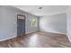A light-filled living room with wood floors, light-gray walls, and a blue front door at 1411 Cliff Ave, Eustis, FL 32726