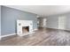 Cozy living room featuring hardwood floors, a decorative fireplace, and ample natural light at 1411 Cliff Ave, Eustis, FL 32726