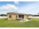 Backyard features a hot tub, retractable awning, outdoor seating, solar panels, and well-maintained lawn at 1444 Daystar Ln, Deltona, FL 32725
