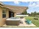 Landscaped backyard featuring a hot tub, retractable awning, outdoor seating, and well-maintained lawn at 1444 Daystar Ln, Deltona, FL 32725