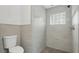 Updated bathroom featuring tiled shower with glass block window, and updated toilet at 1518 Lakeside Dr, Deland, FL 32720